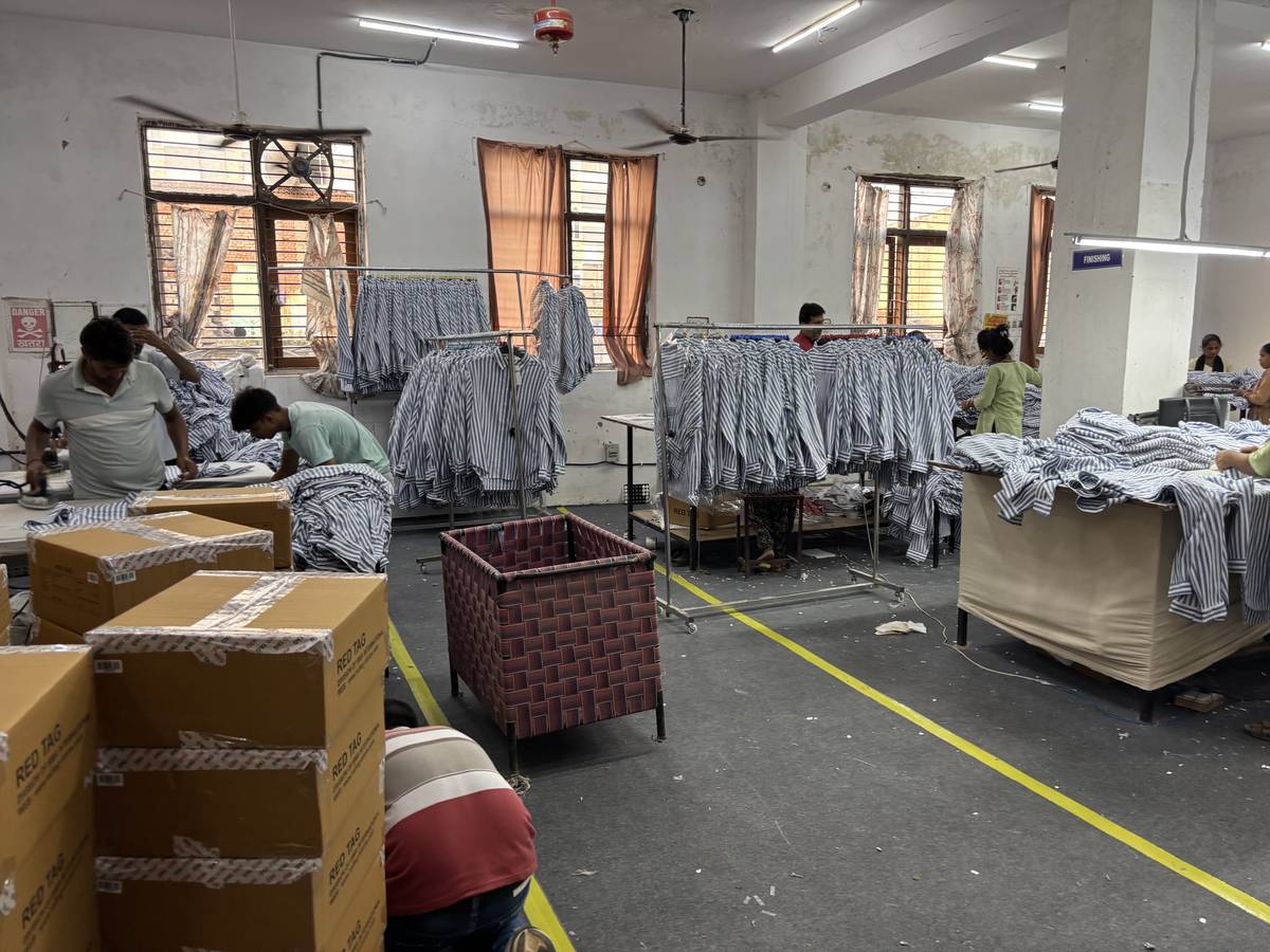Wide view of the Alliance Company finishing department with garment rails and folding tables